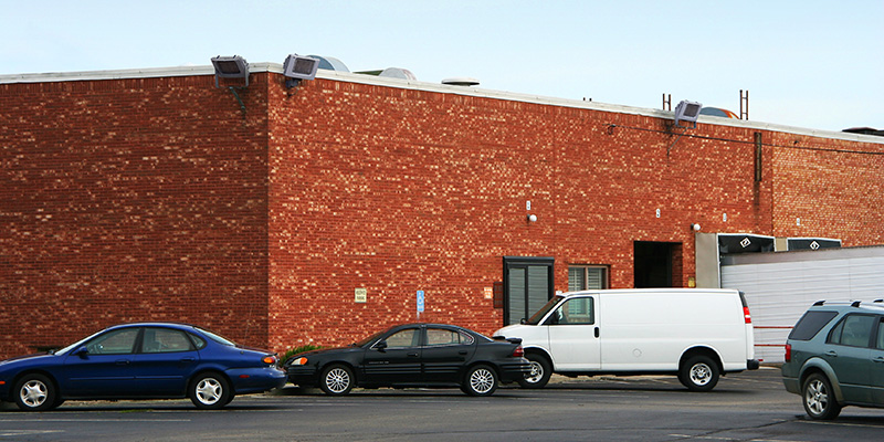 ACP LED floodlights by American Electric Lighting installed to the side of commercial building to enhance safety.