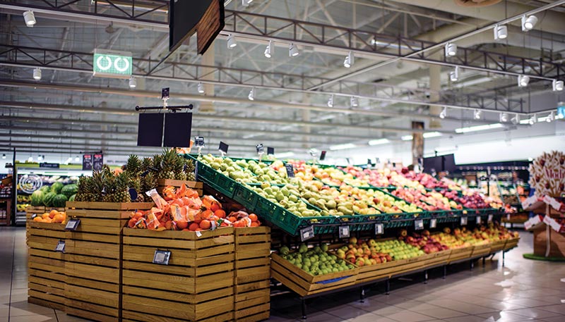 Juno LED track lighting system illuminates the produce section of a grocery store.