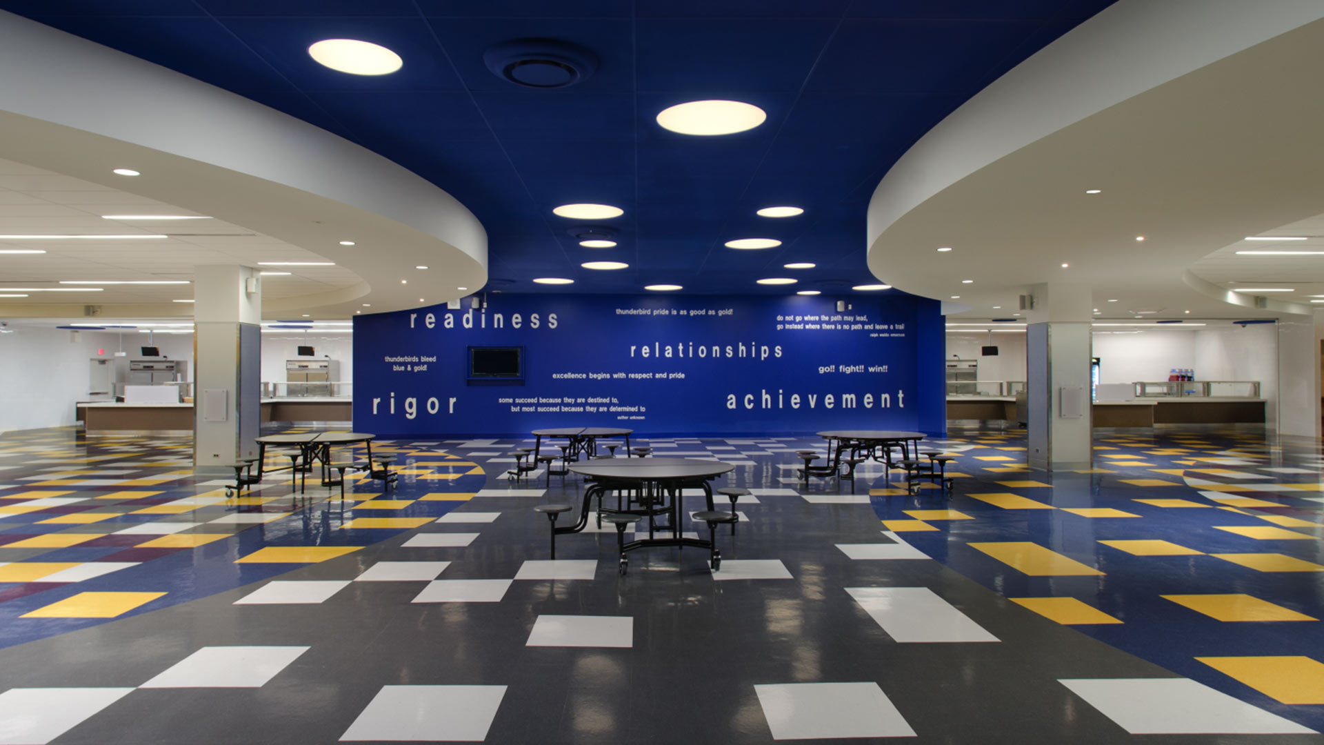 Direct ceiling recessed luminaire in large school cafeteria.